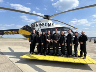 Photo of new hires in front of a STAT MedEvac helicopter